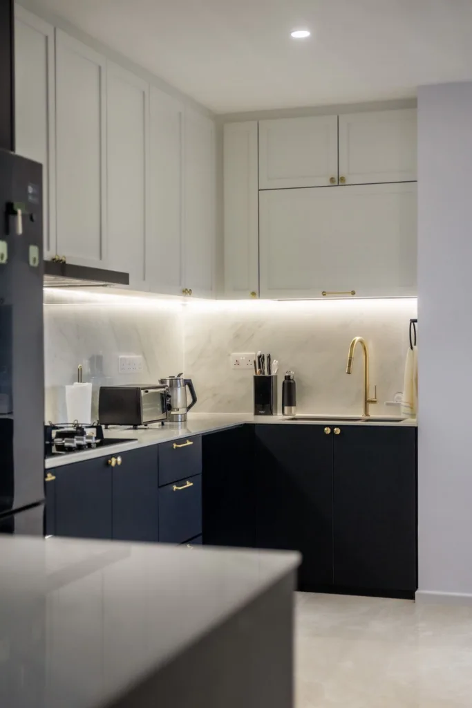 Modern kitchen with marble backsplash and gold accents.