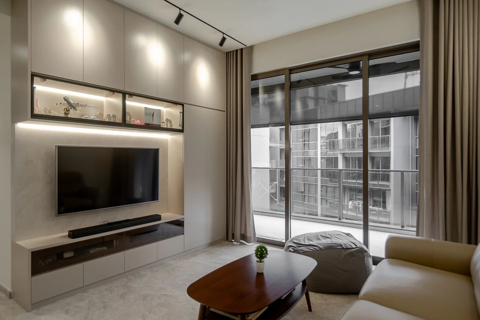 Modern living room with built-in entertainment center, large window, and comfortable sofa.