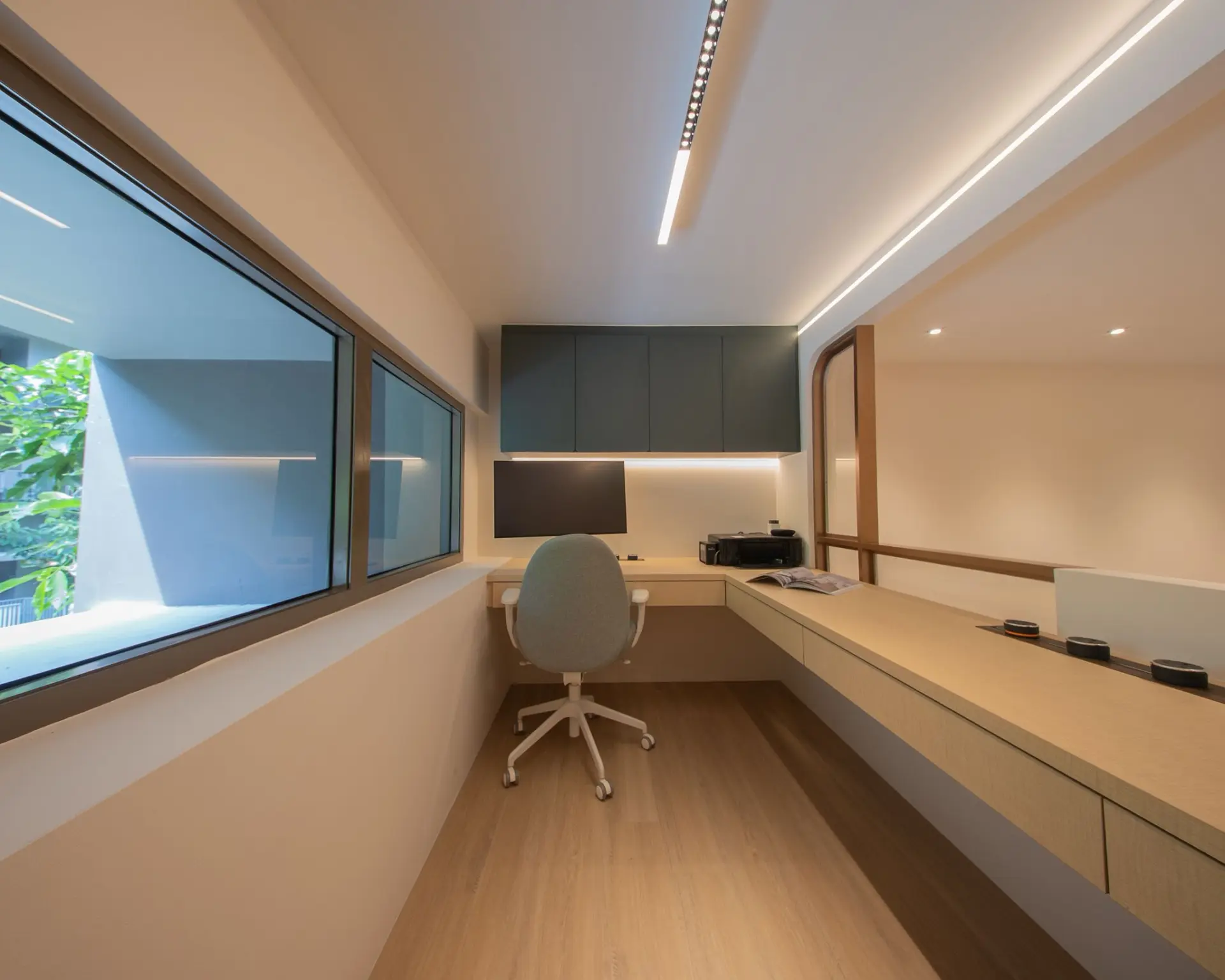 Modern home office with desk and large window.